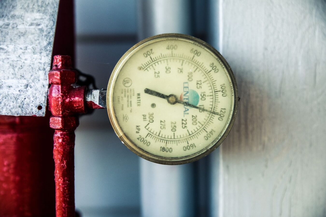 mechanic testing radiator cap pressure with gauge