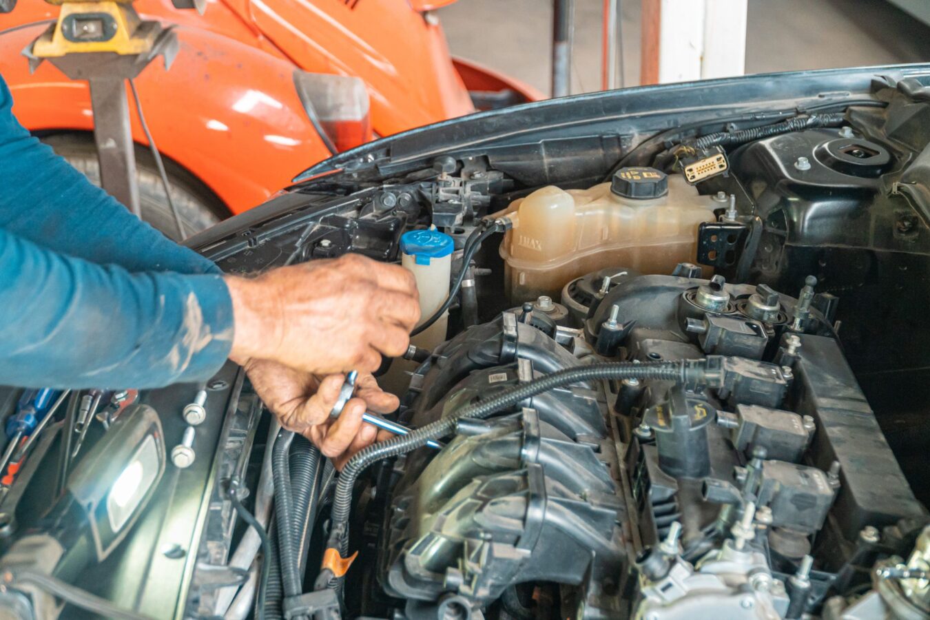 mechanic checking serpentine belt tensioner with torque wrench