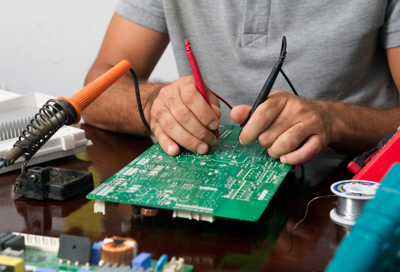 mechanic testing glow plug control module with multimeter