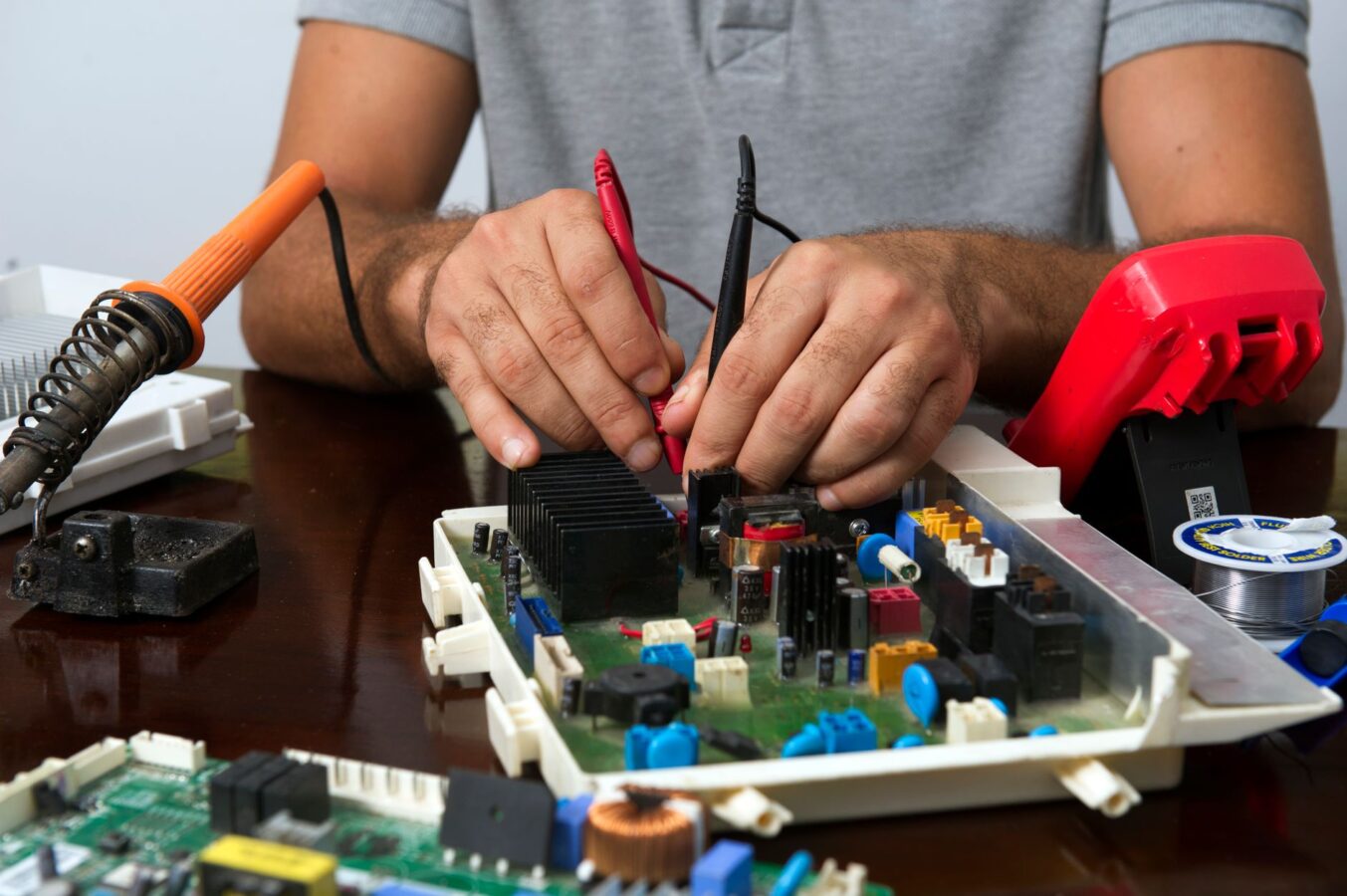 mechanic testing car radio with multimeter probes