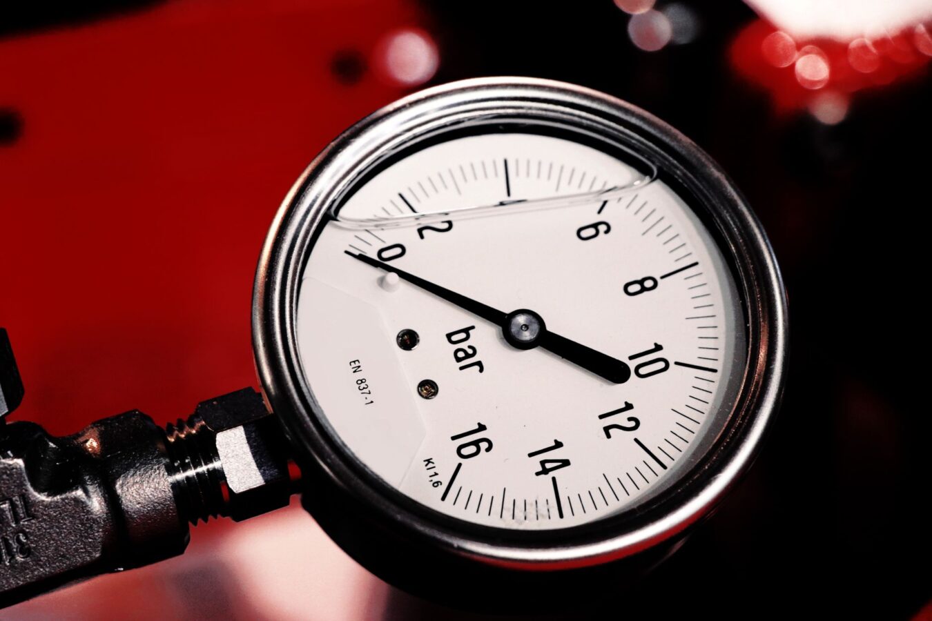 mechanic testing fuel pressure with gauge on rail