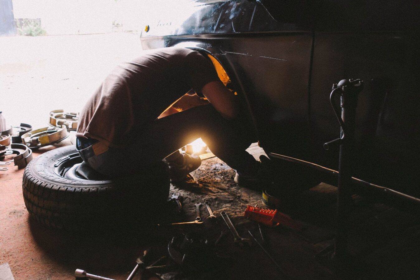 mechanic replacing brake caliper piston with tool