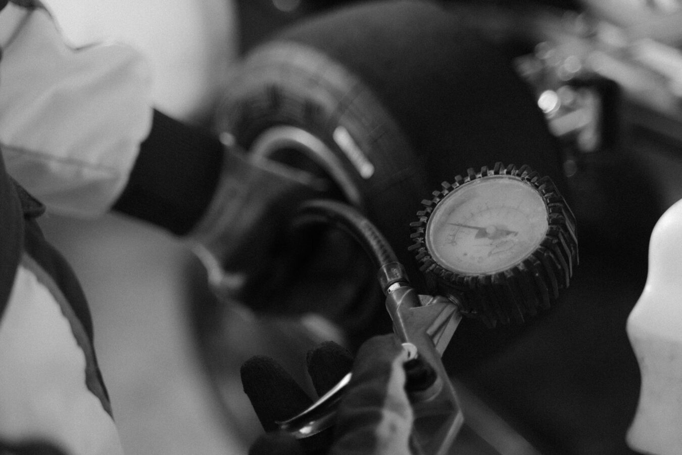 Mechanic checking tire tread depth with gauge