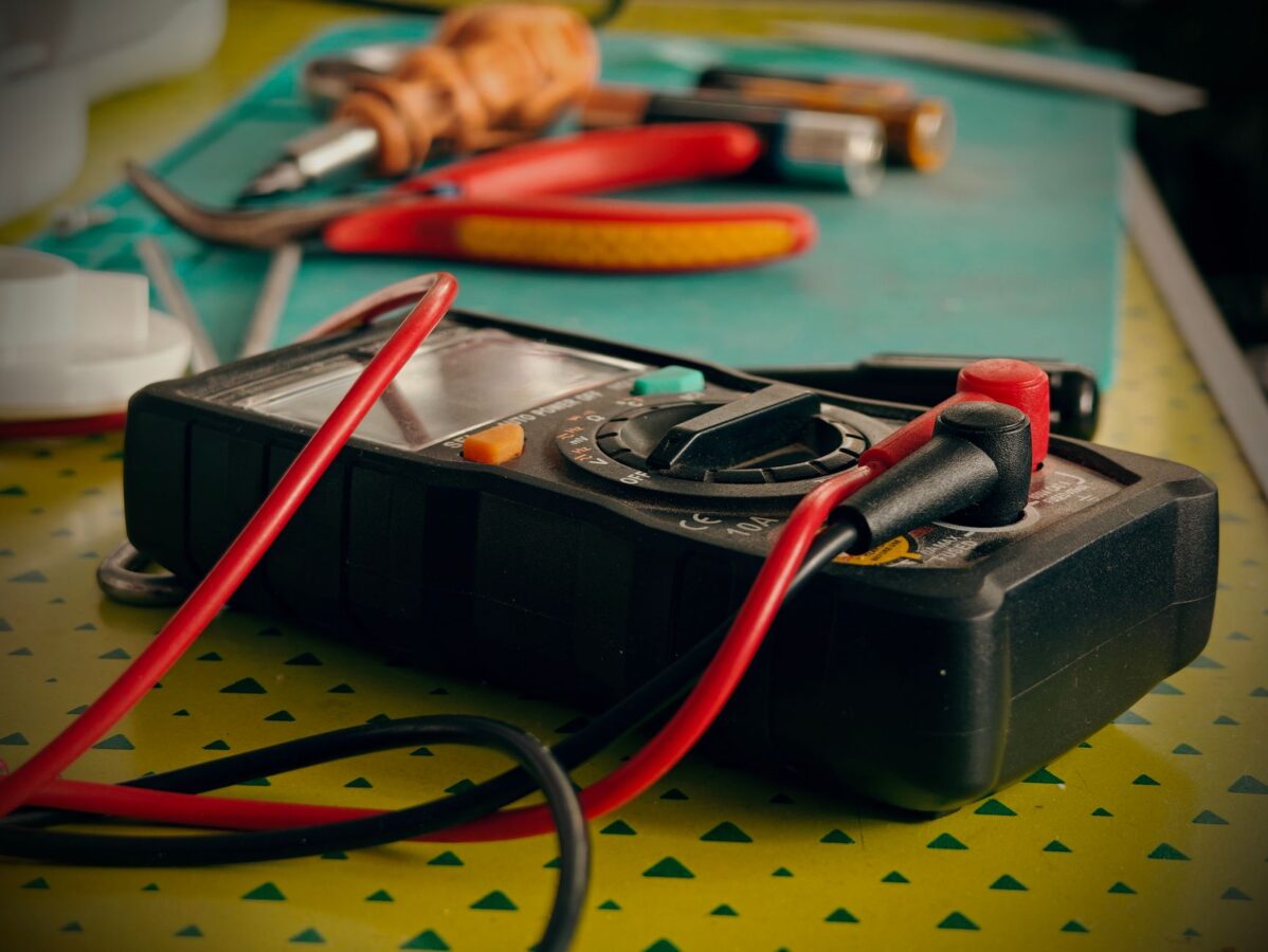 mechanic testing fuel sender unit with multimeter