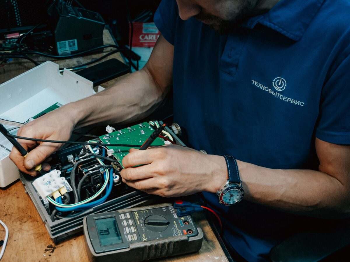 mechanic testing glow plug resistance with multimeter
