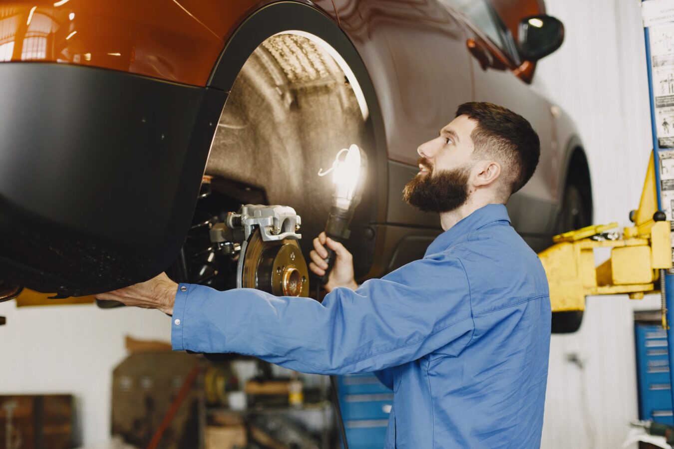 mechanic inspecting turbocharger variable vane mechanism with flashlight