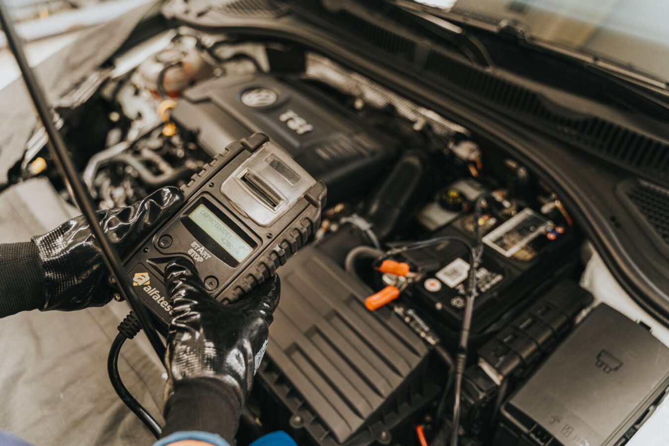 mechanic testing radiator cap with pressure tester