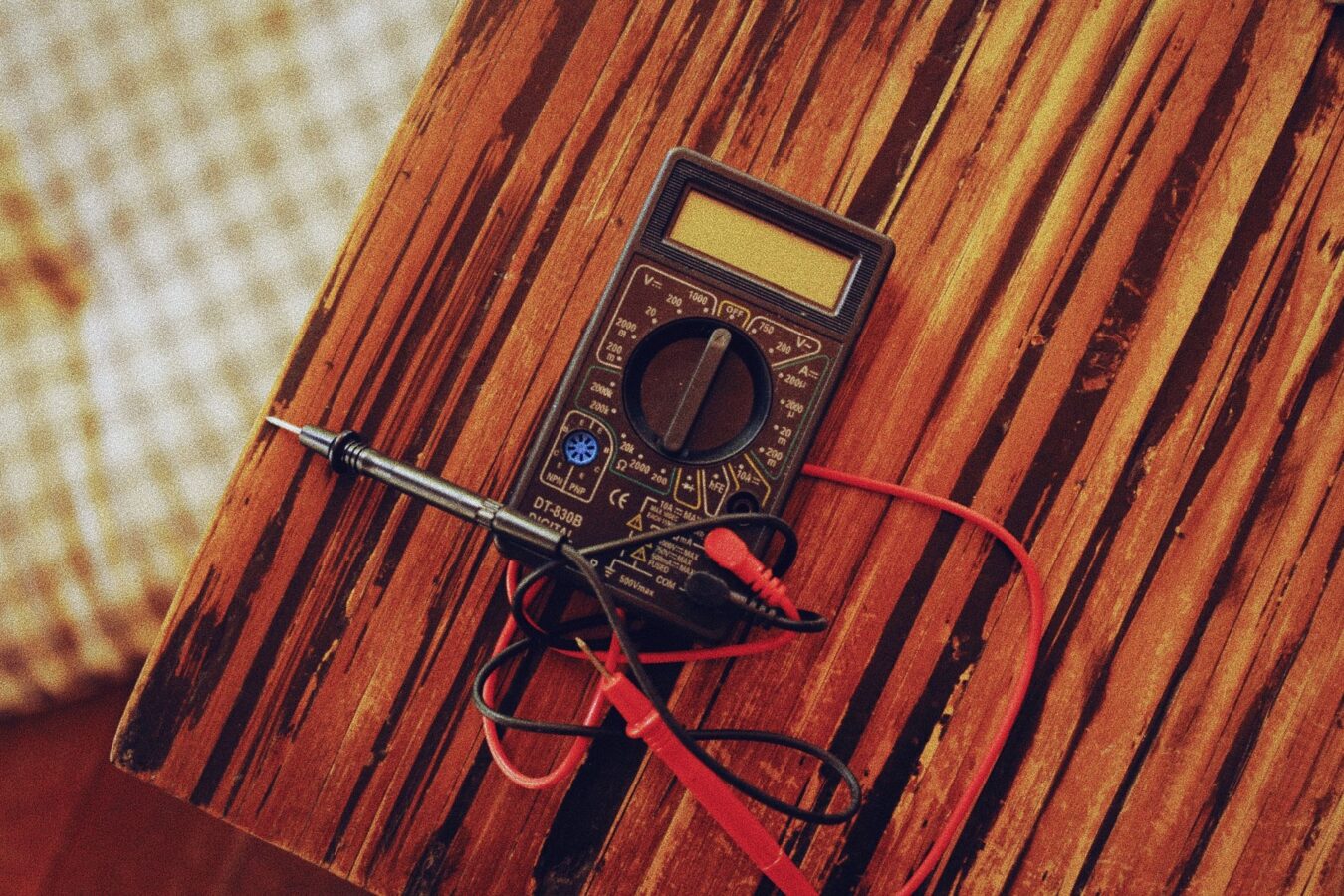 mechanic testing fuel injector with multimeter and pressure gauge